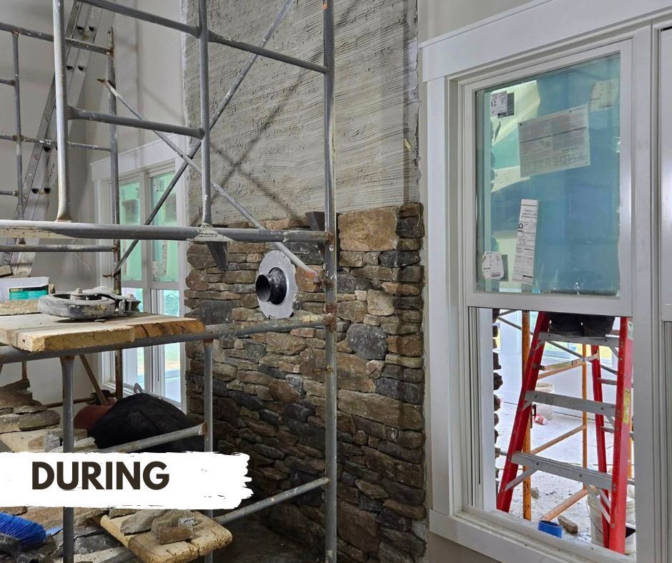 Stone veneer installation in a room with scaffolding, a window, and a ladder. During construction, the wall shows partially completed stone.