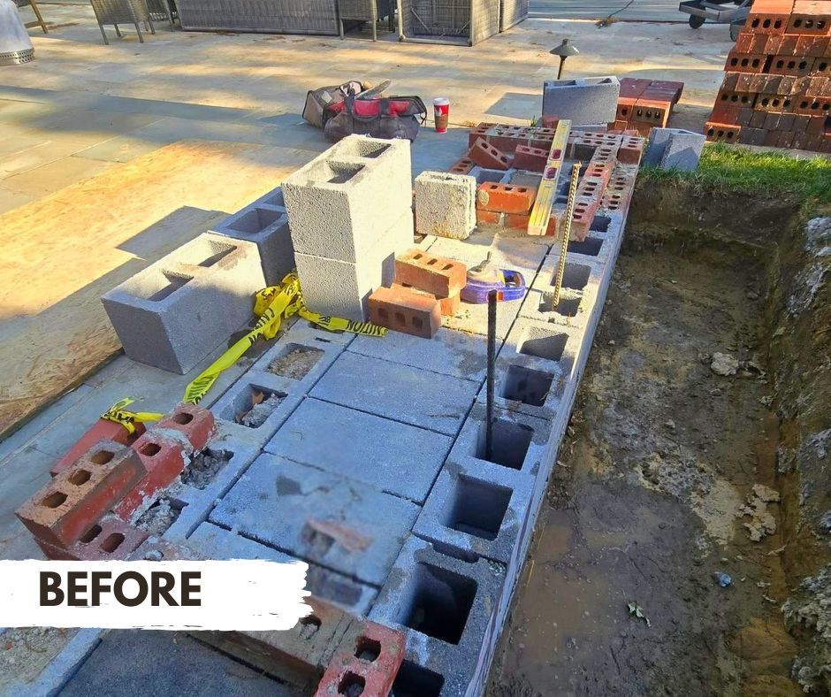 Construction site with concrete blocks and red bricks arranged on a foundation, preparing for a build.