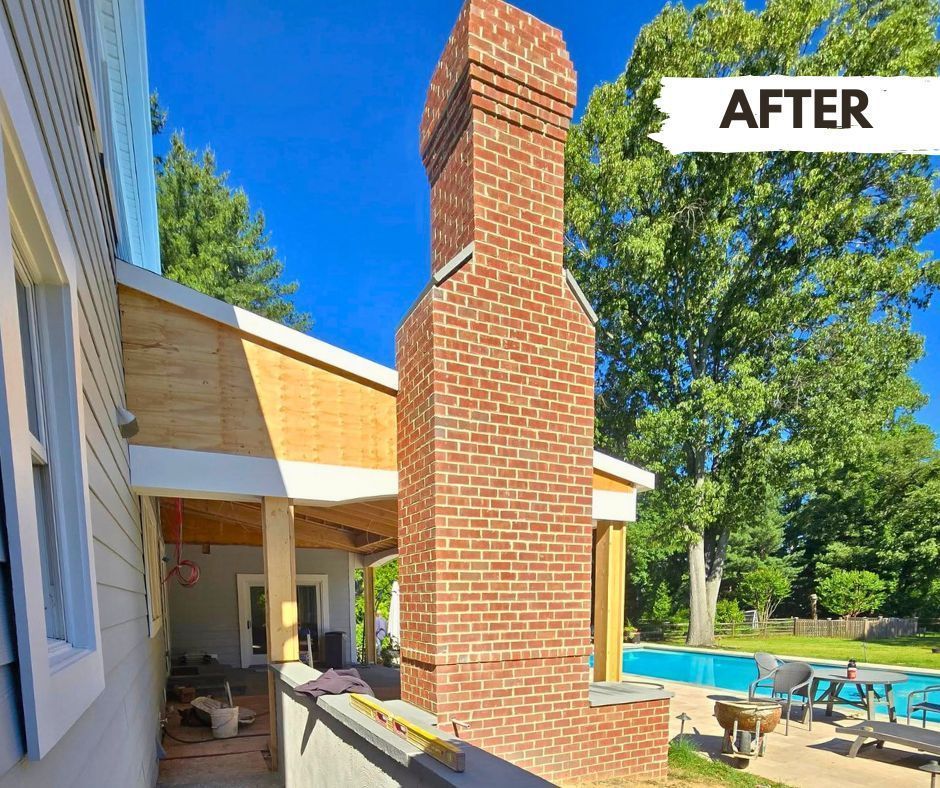 Newly constructed red brick chimney on a house with a pool visible in the background;