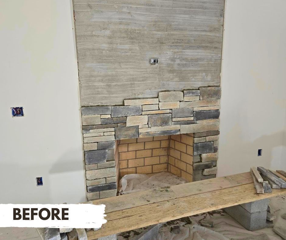 Fireplace under construction: gray and tan stone veneer partially installed over a brick fireplace. A mortar-covered wall is above.