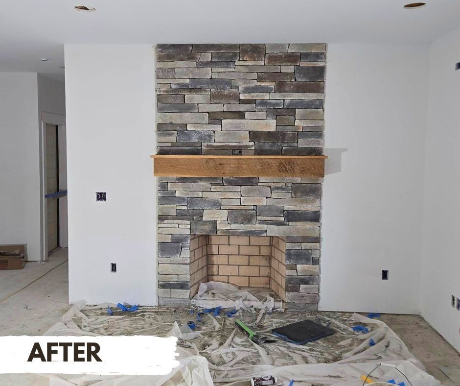 A newly renovated fireplace with stone facade and wooden mantel. The room is under construction with protective coverings on the floor.