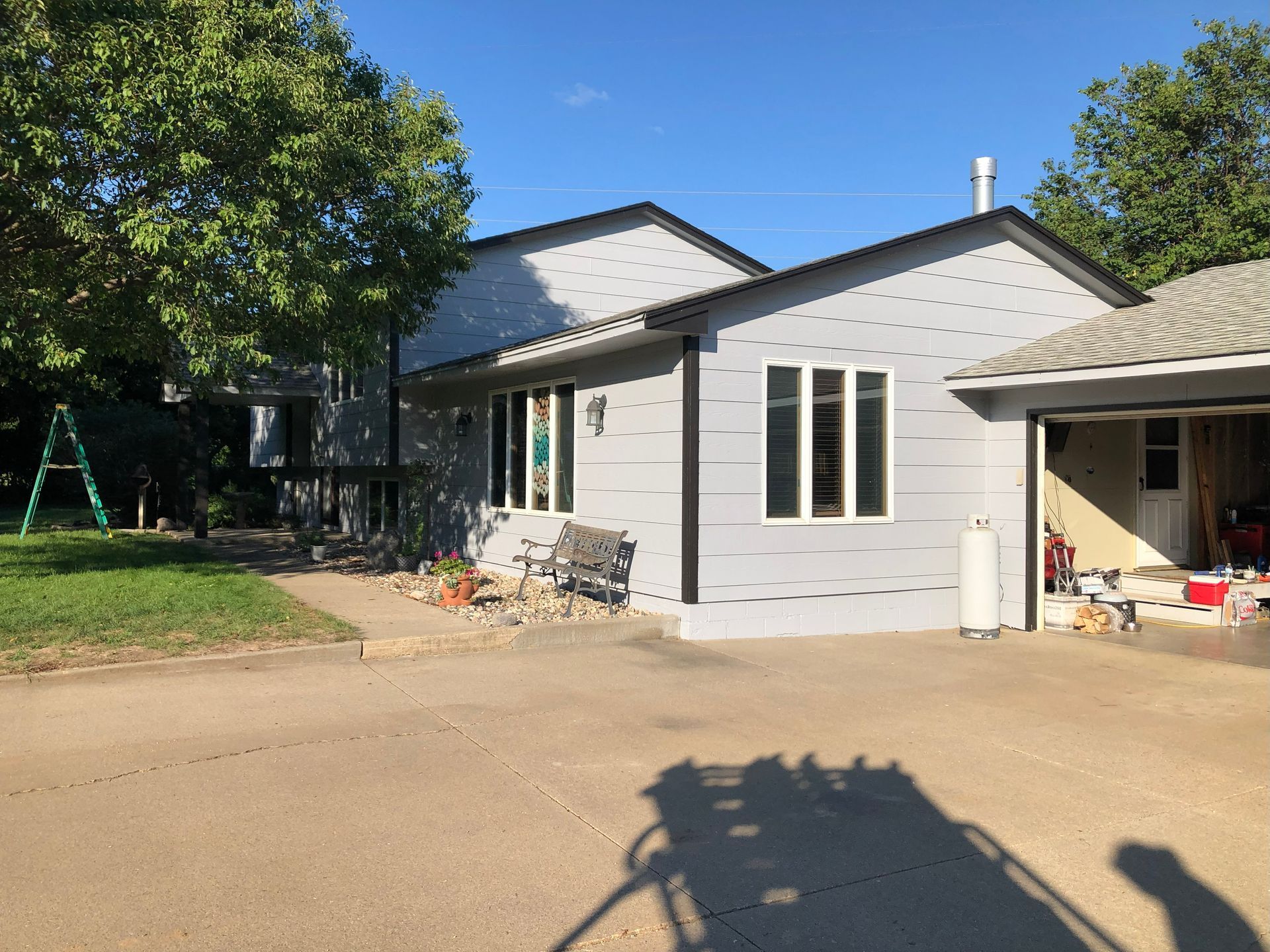 Gray house with black trim, windows, and attached garage on a sunny day.