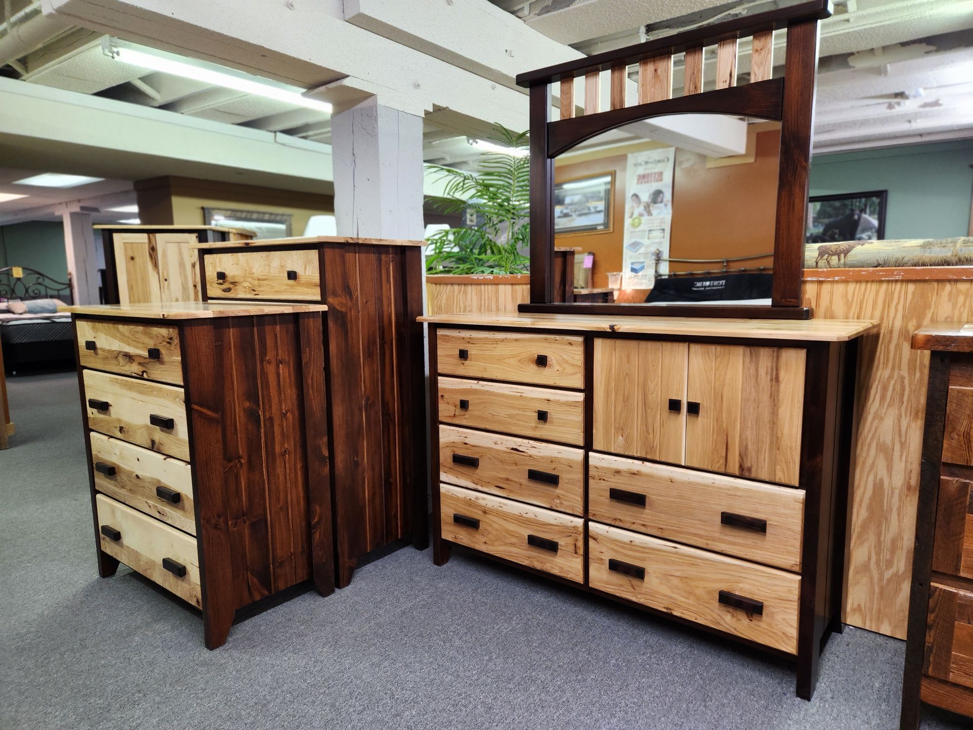 A bedroom set made of wood with a dresser, nightstand, and mirror.