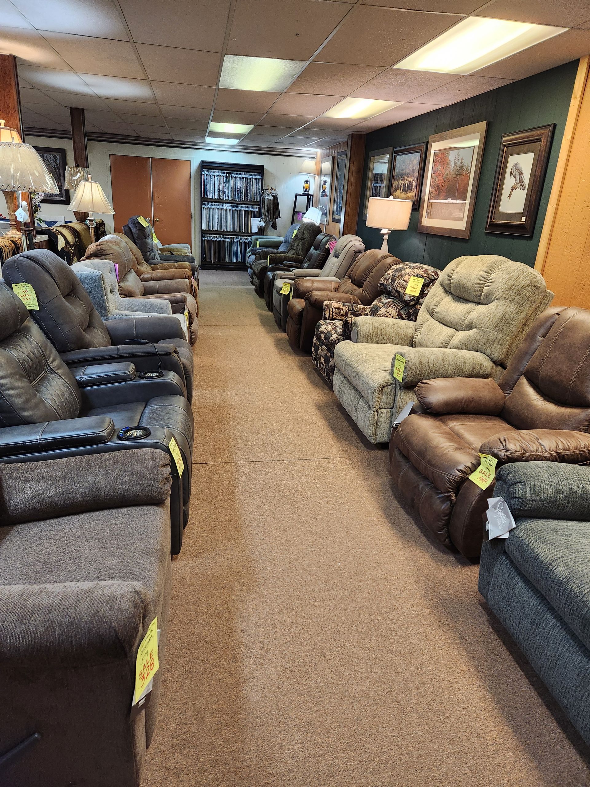 A row of recliner chairs are lined up in a store.