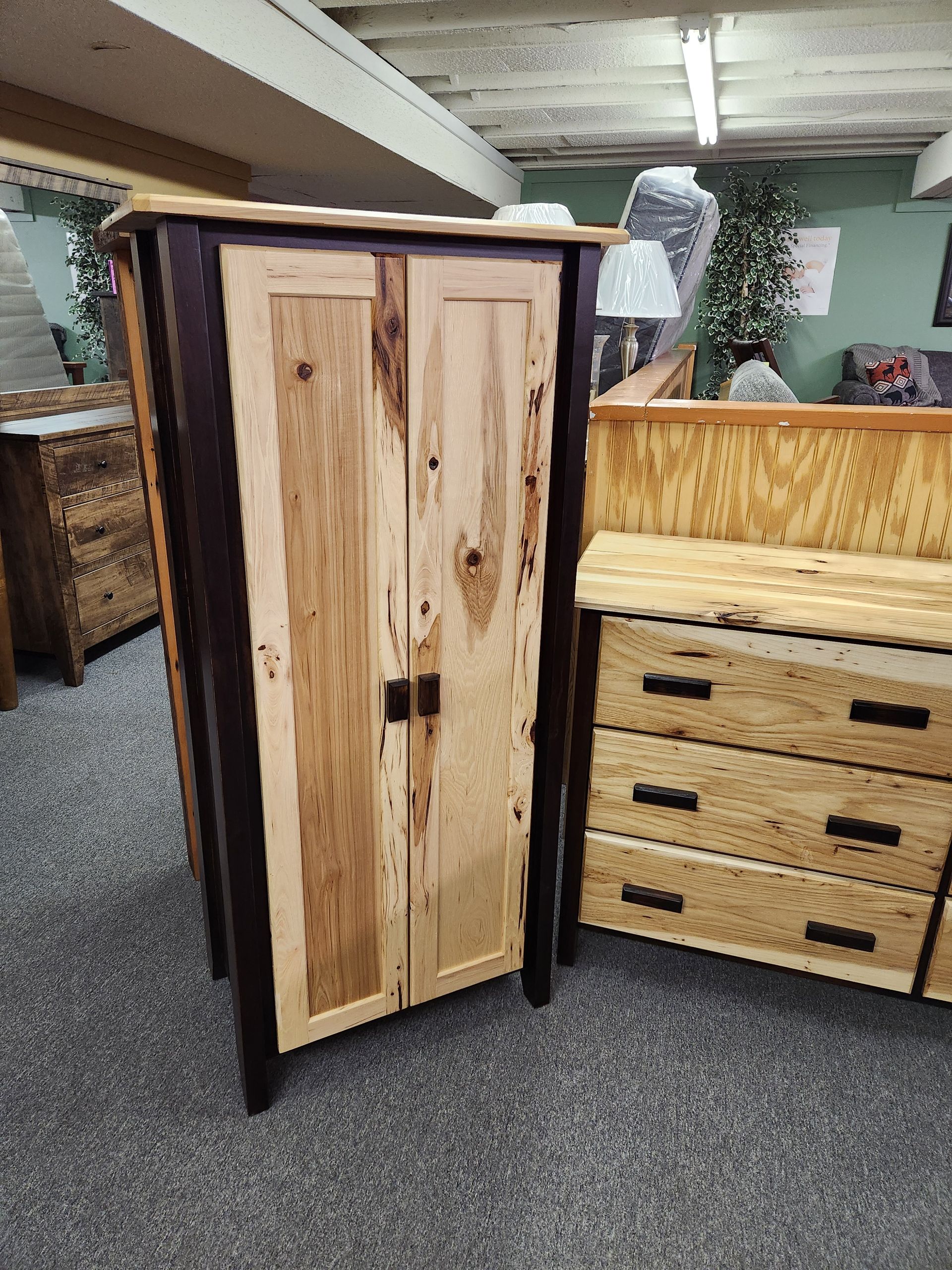 A wooden wardrobe and dresser are sitting next to each other in a room.