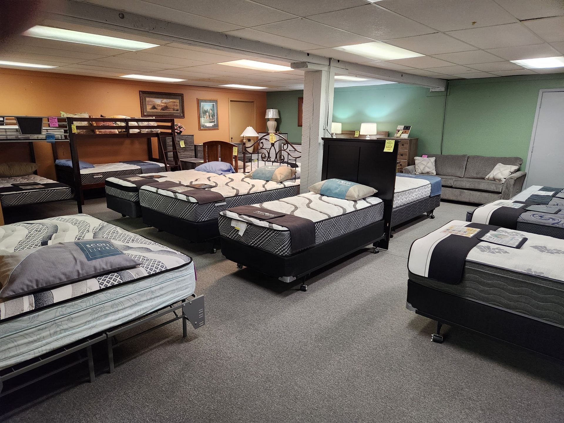 A mattress store filled with lots of mattresses and furniture.