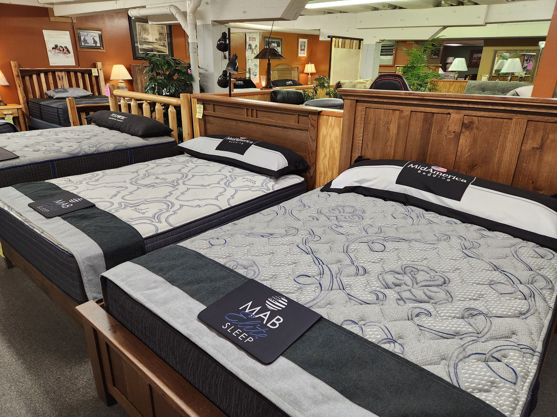 Three beds are lined up in a mattress store.