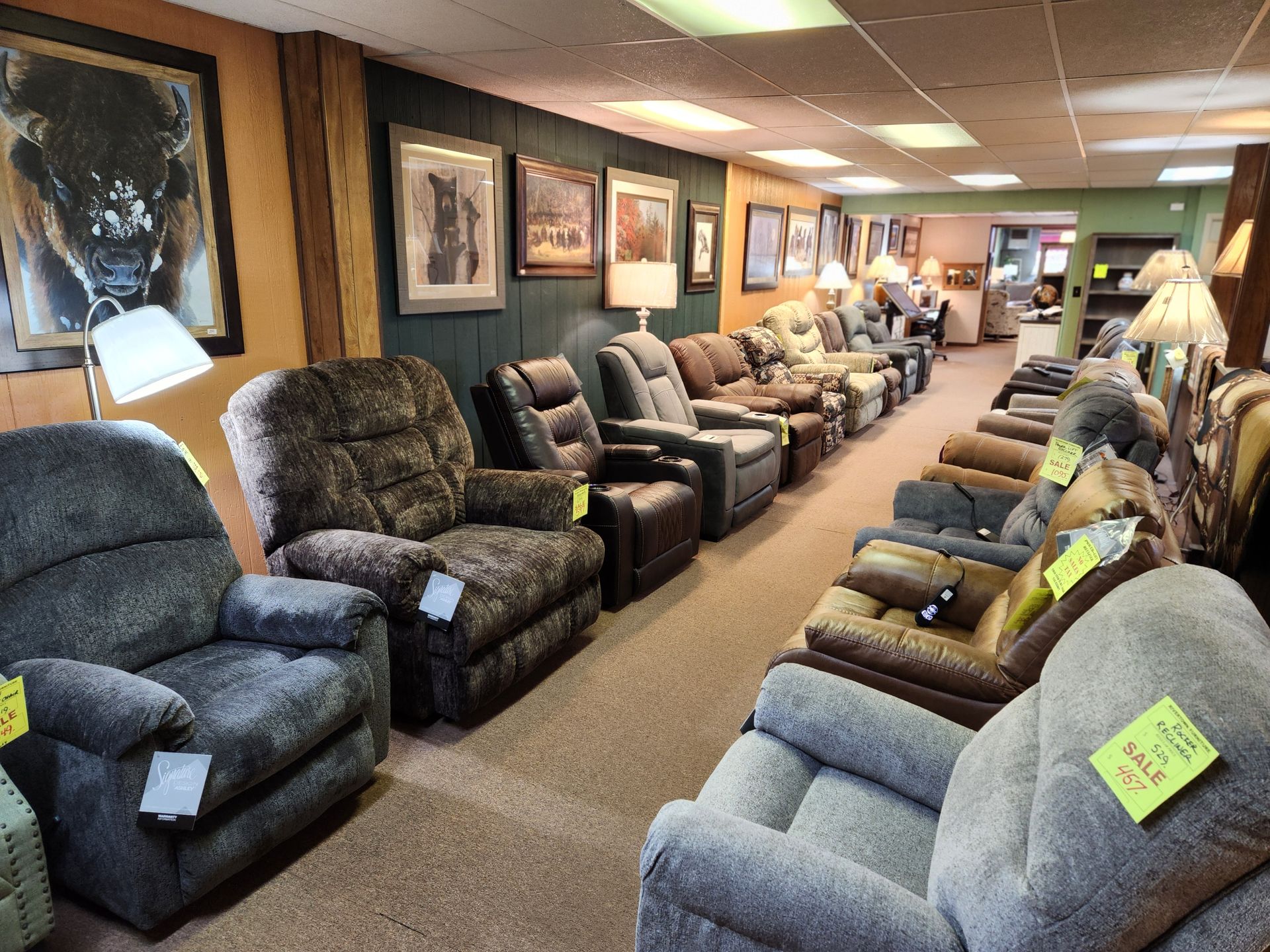 A row of recliner chairs are lined up in a store.