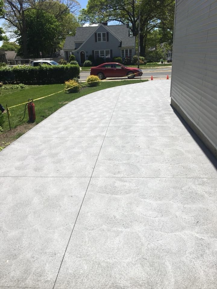 A red car is parked in the driveway of a house.