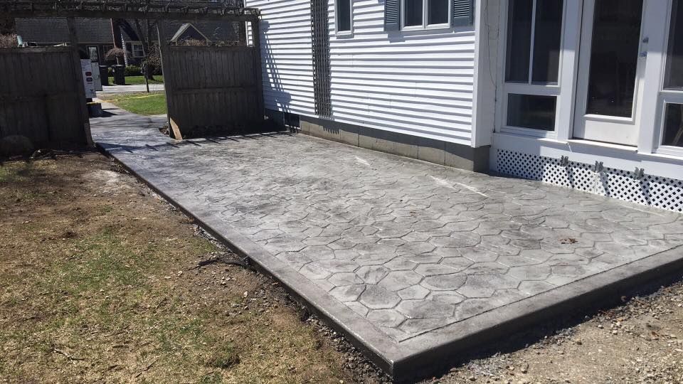 A concrete patio is being built in front of a house.