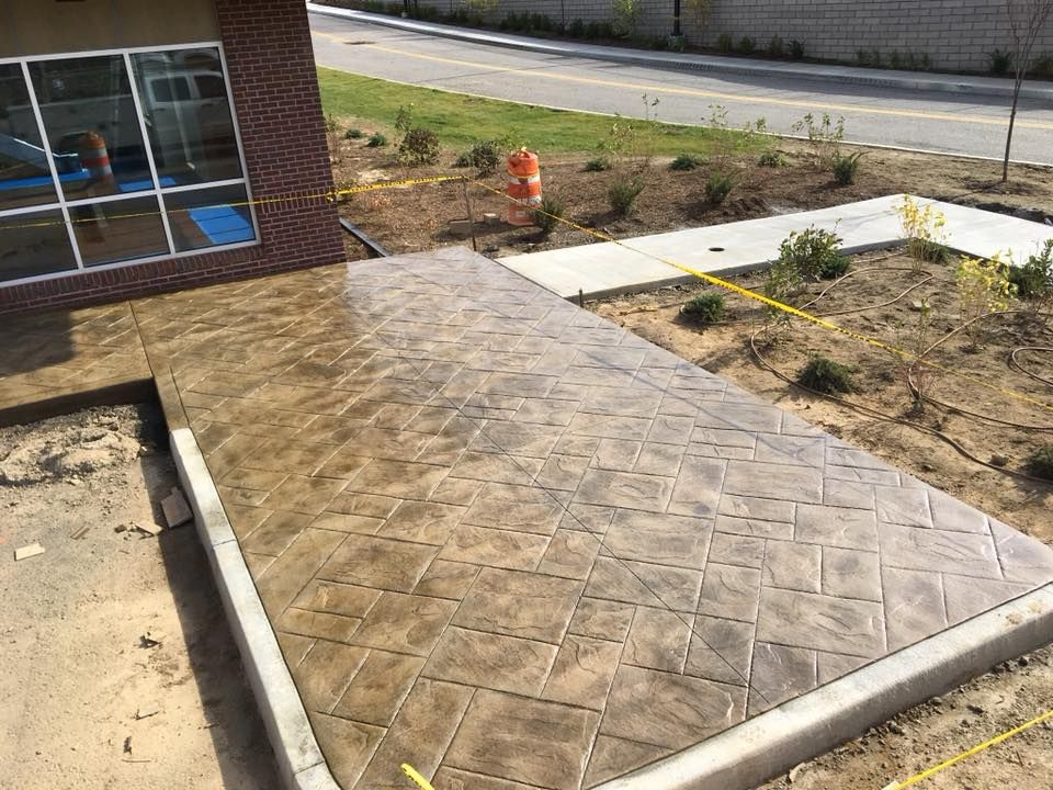 A concrete walkway is being built in front of a building.