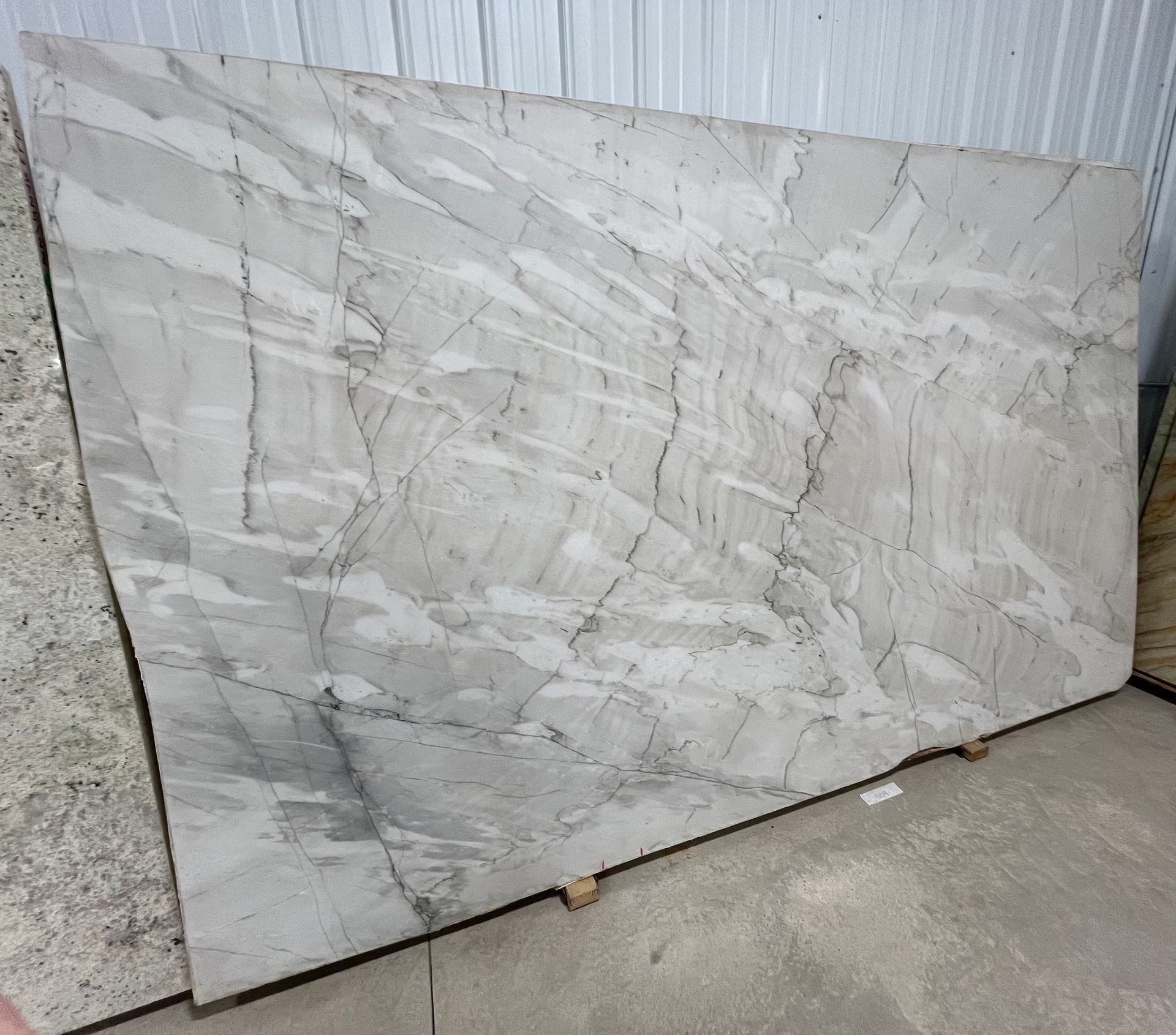 A large white marble slab is sitting on top of a concrete floor.
