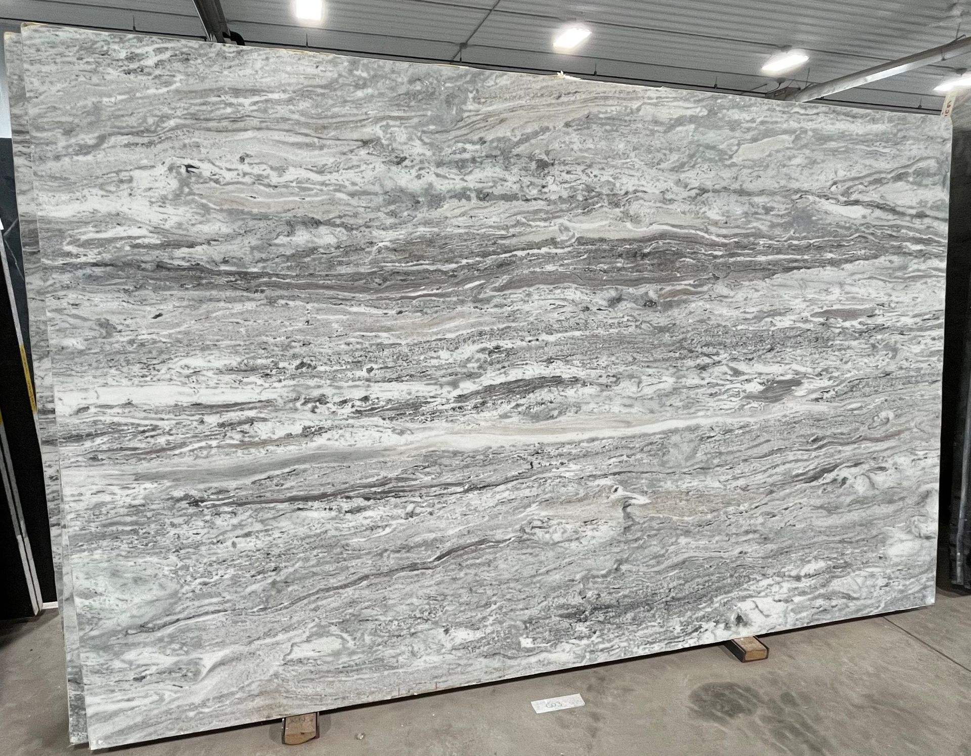 A large white granite slab is sitting on top of a wooden pallet.