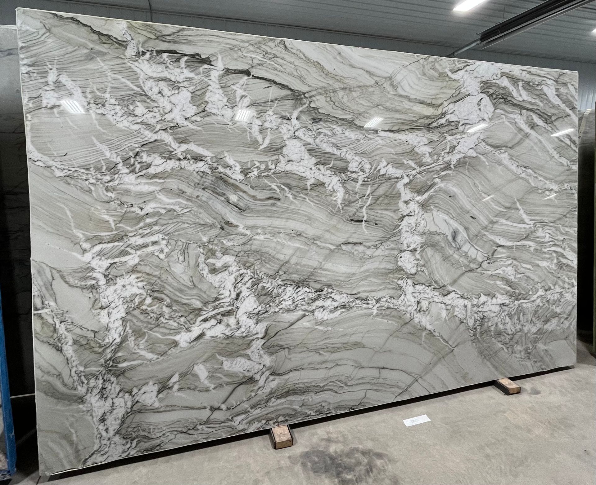 A large slab of marble is sitting on top of a cement floor.