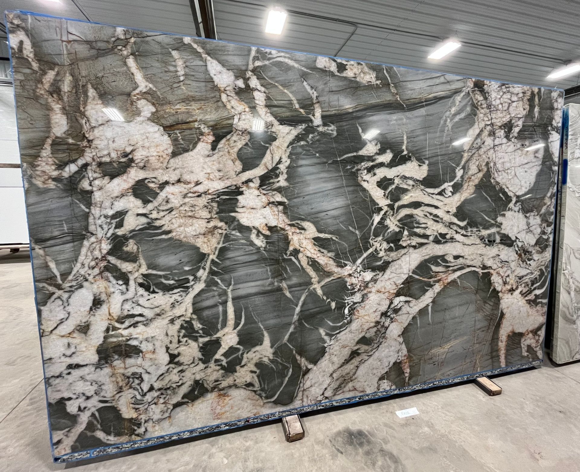 A large slab of marble is sitting on top of a concrete floor in a warehouse.