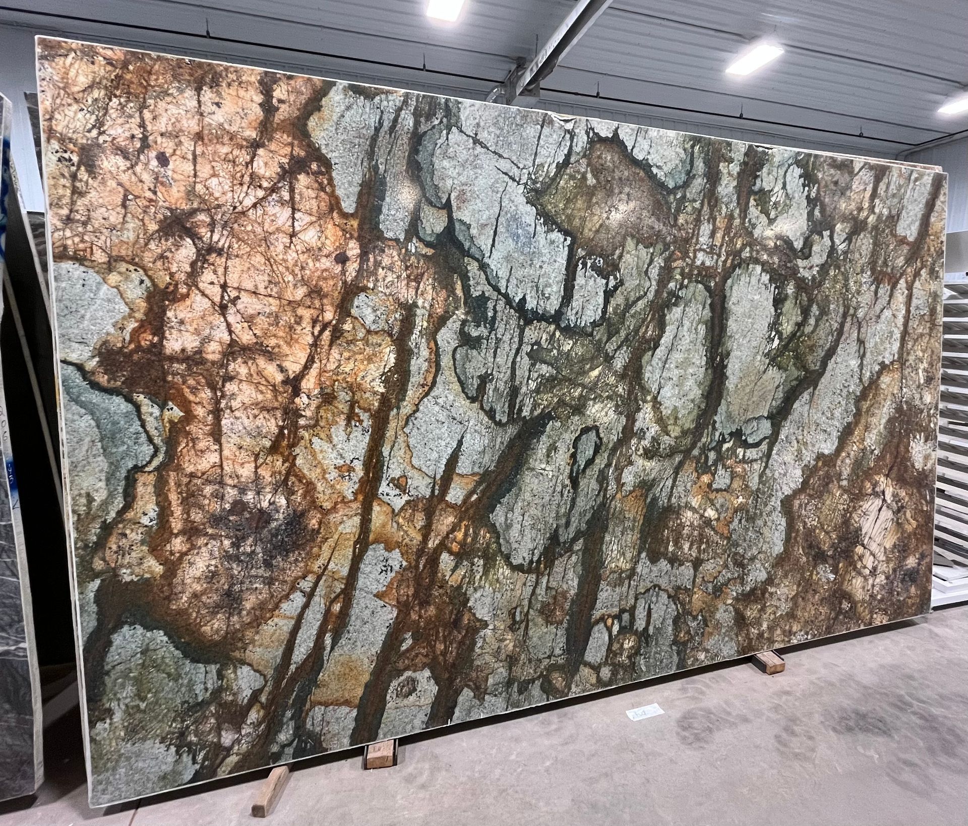 A large slab of granite is sitting on the floor in a warehouse.