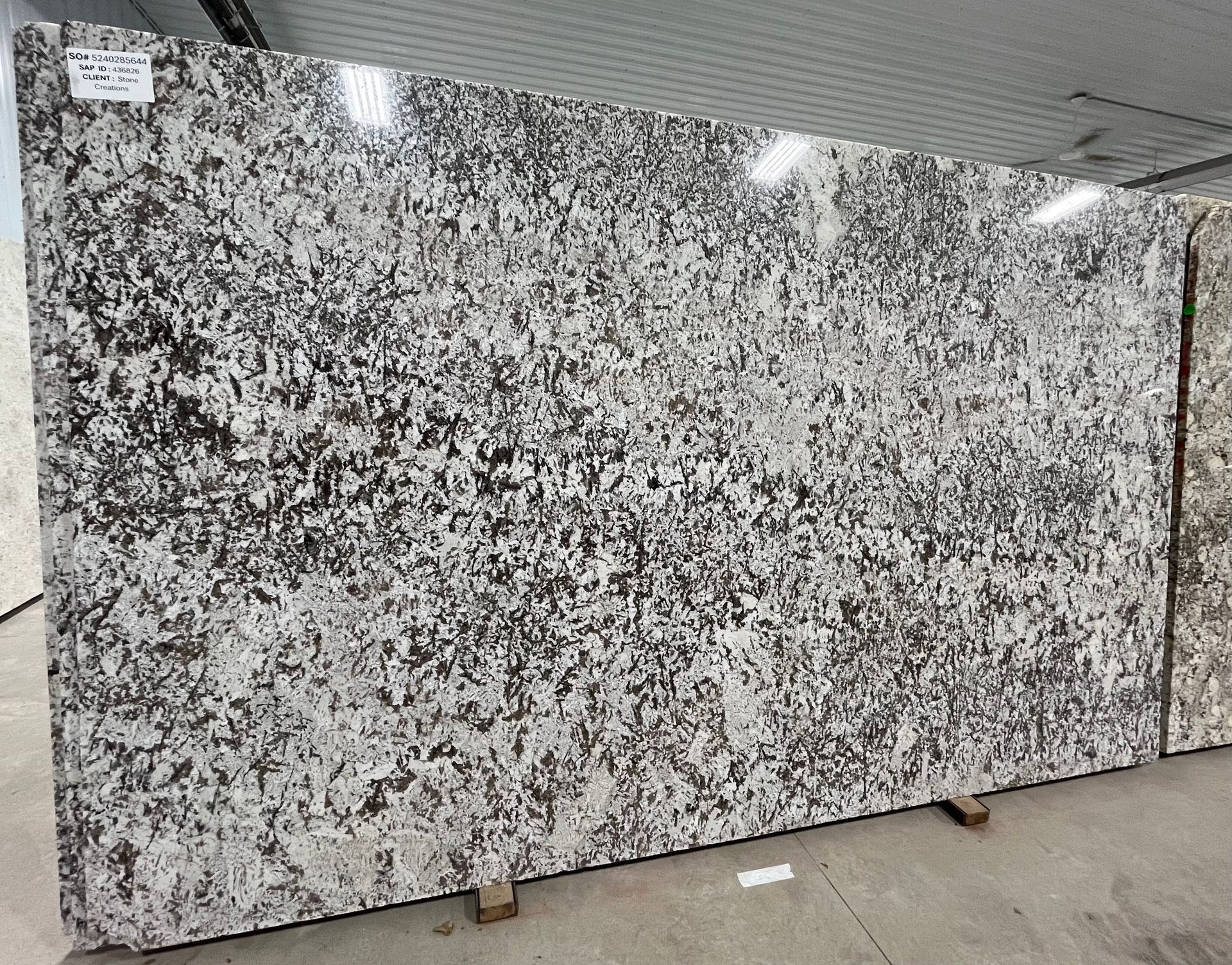 A large slab of granite is sitting on top of a concrete floor.