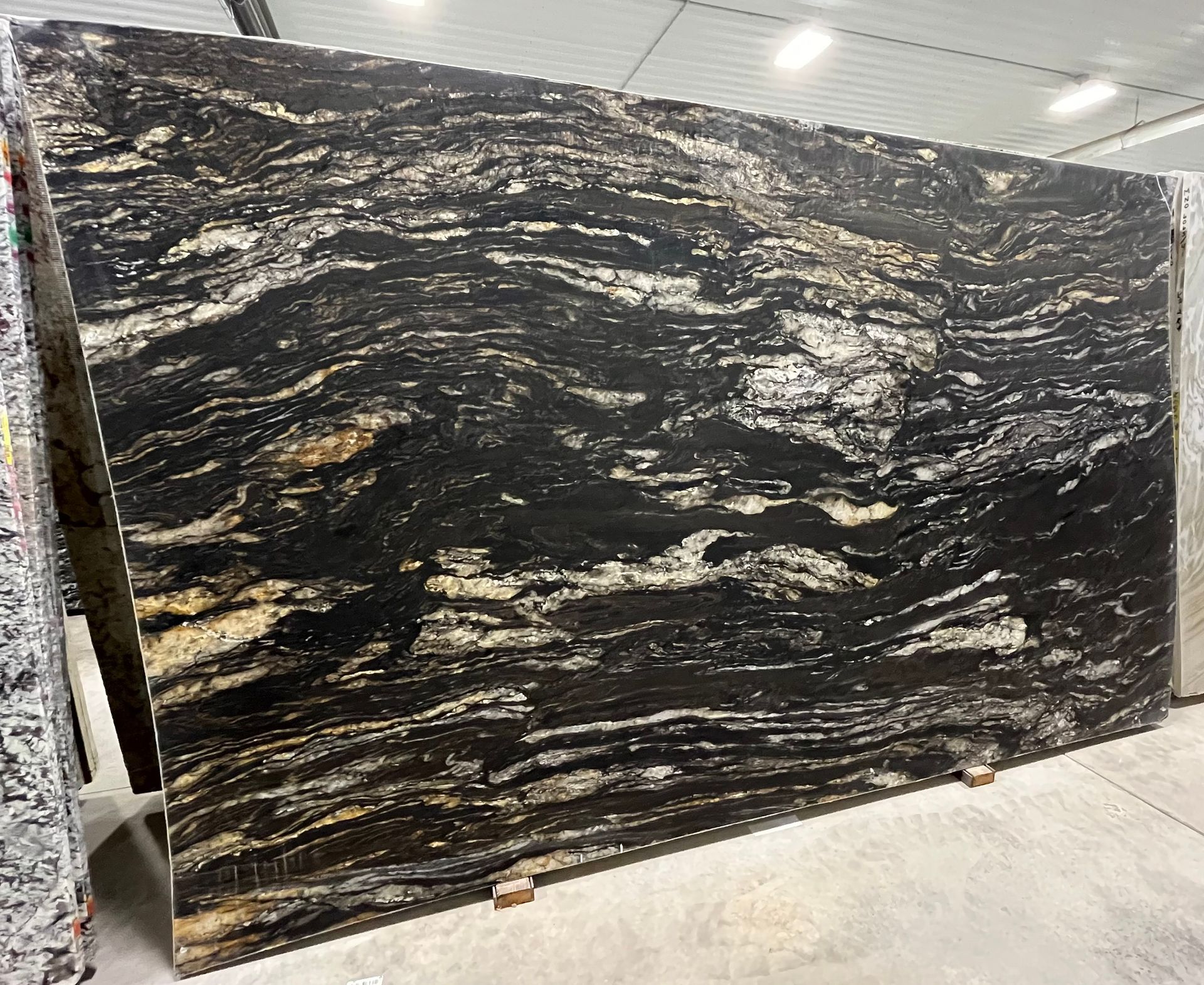 A large black granite slab is sitting on top of a concrete floor.