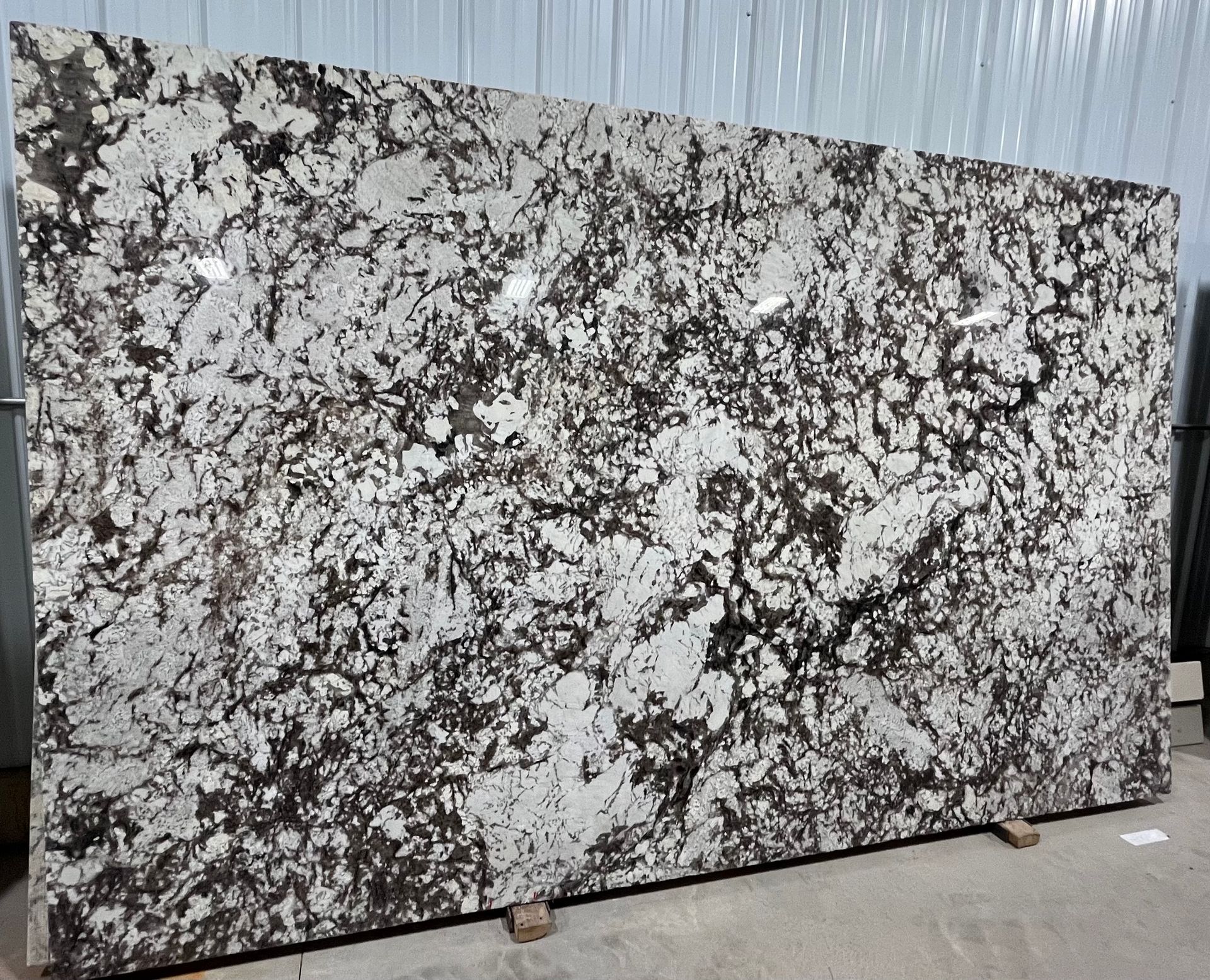 A large slab of granite is sitting on top of a wooden pallet.