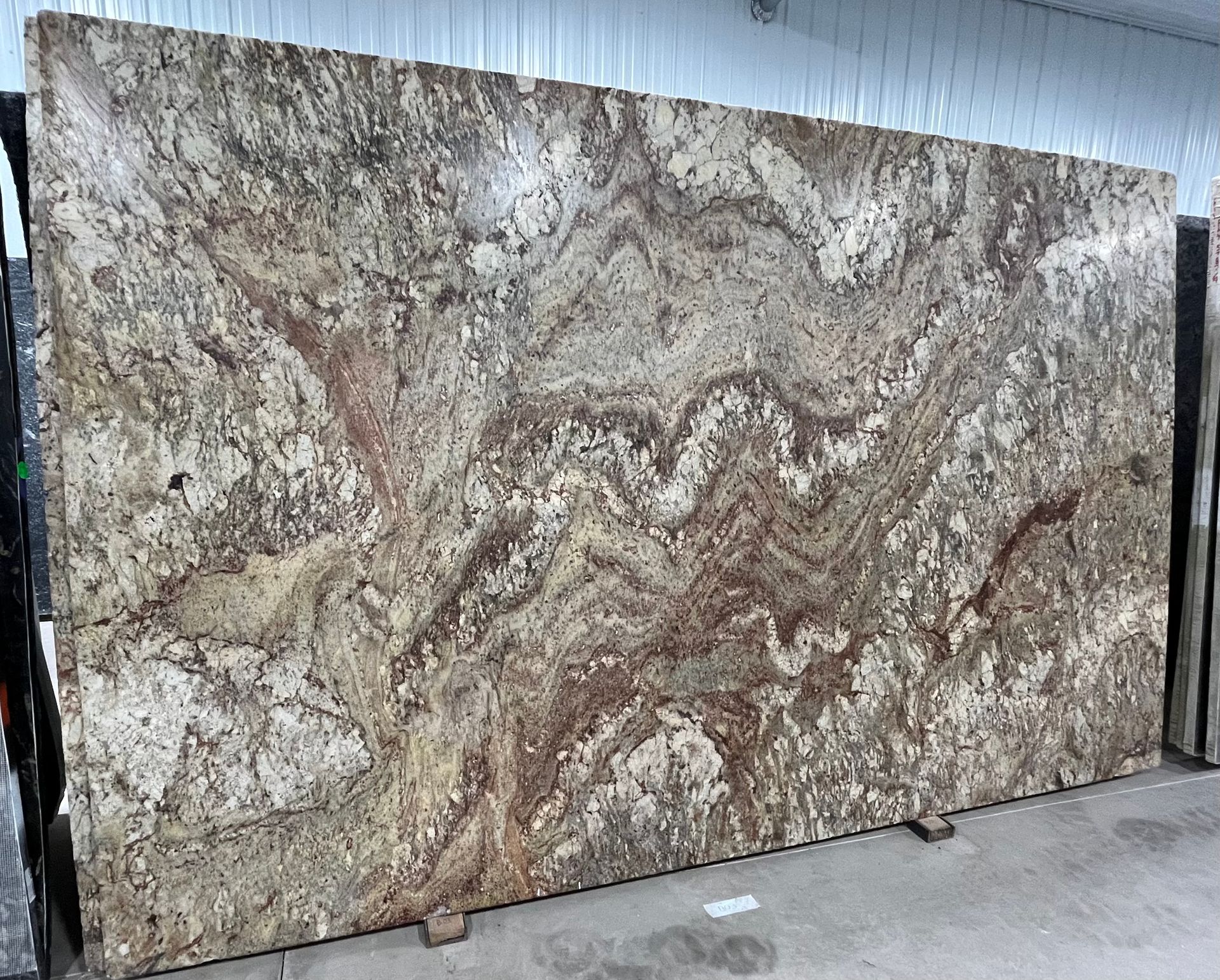 A large slab of granite is sitting on top of a cement floor.