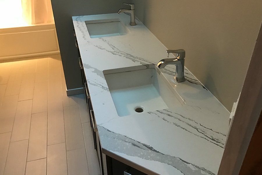 A bathroom with two sinks and a faucet on a counter.