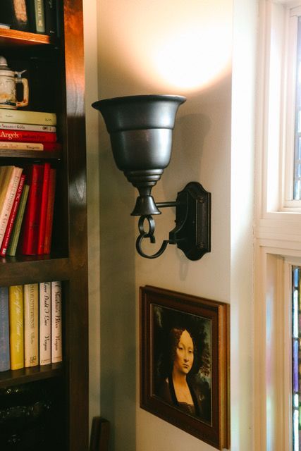 A lamp is hanging on a wall next to a picture of a woman