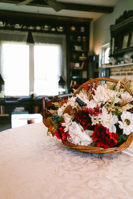 A basket of flowers is sitting on a table in a living room.