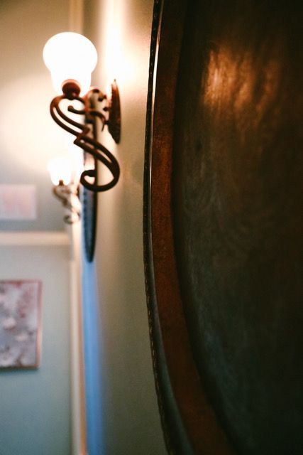 A lamp is hanging on a wall next to a mirror