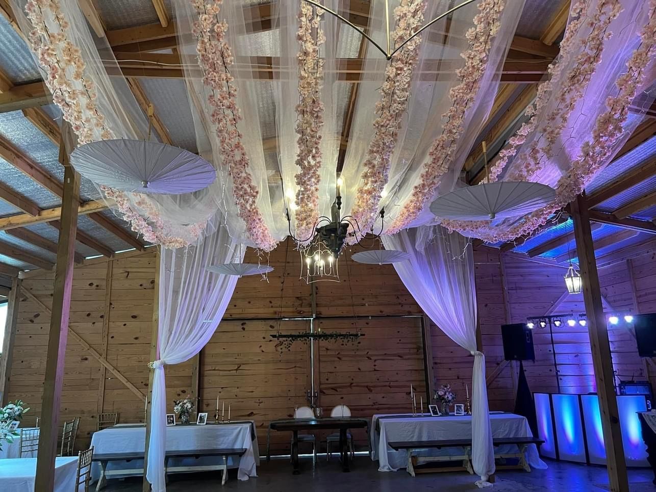 A large room with tables and chairs and a canopy hanging from the ceiling.
