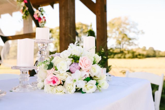 A table with a bouquet of flowers and candles on it.