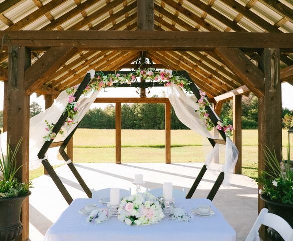 A table with flowers and candles under a gazebo