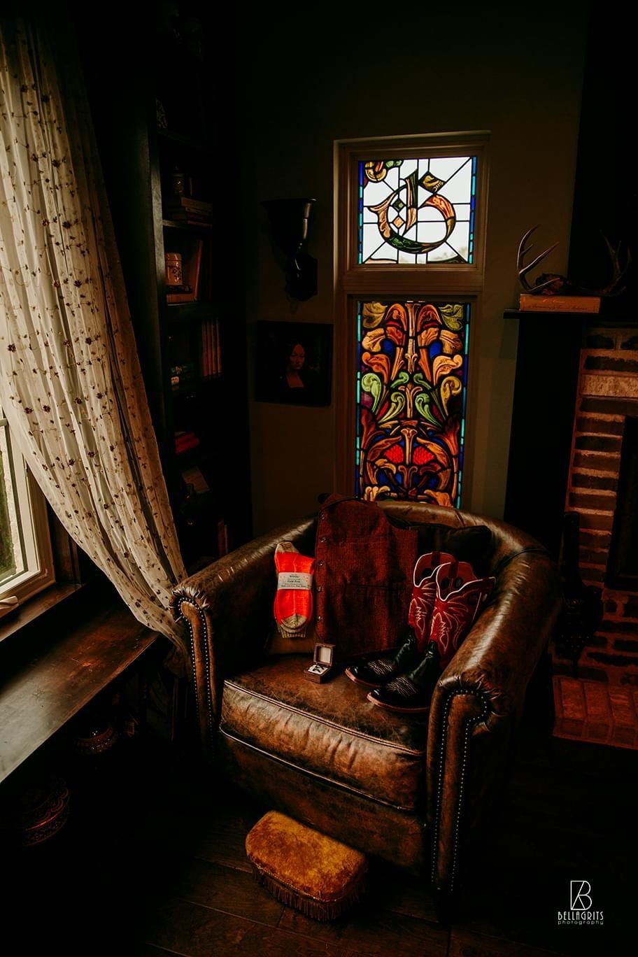 A chair in a room with a stained glass window.
