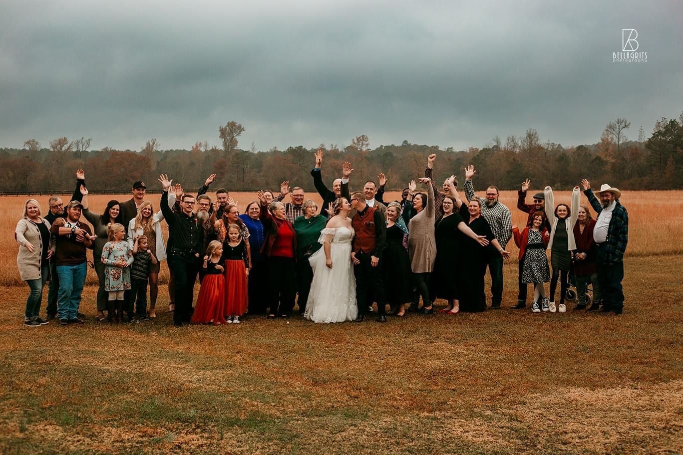 A large group of people are posing for a picture in a field.