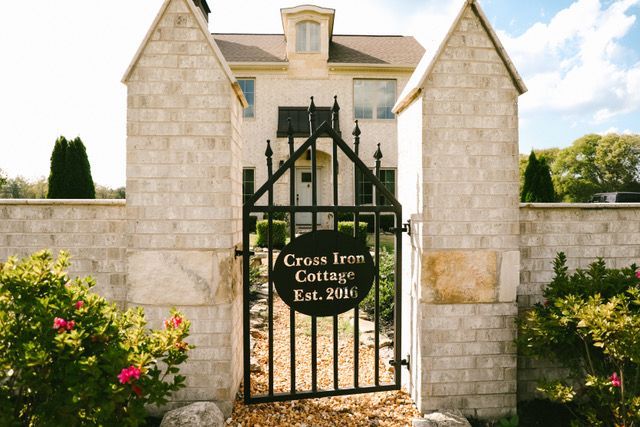 A house with a gate that says cross iron cottage