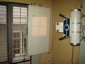 X-ray machine with a viewing screen near a window. Beige wall.