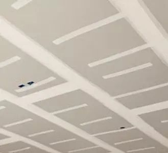 Gray drywall ceiling with recessed square panels and white seams.