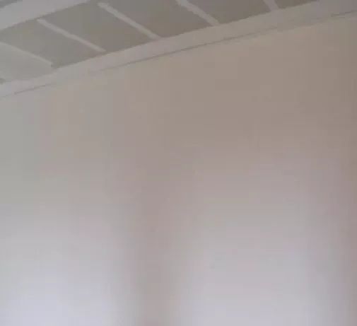 White wall with a ceiling section visible at the top.
