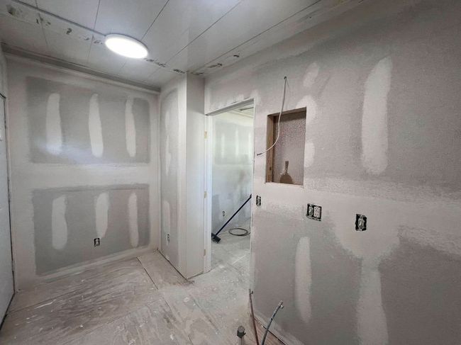 Room under construction with drywall installed.  Electrical boxes and an alcove are visible.
