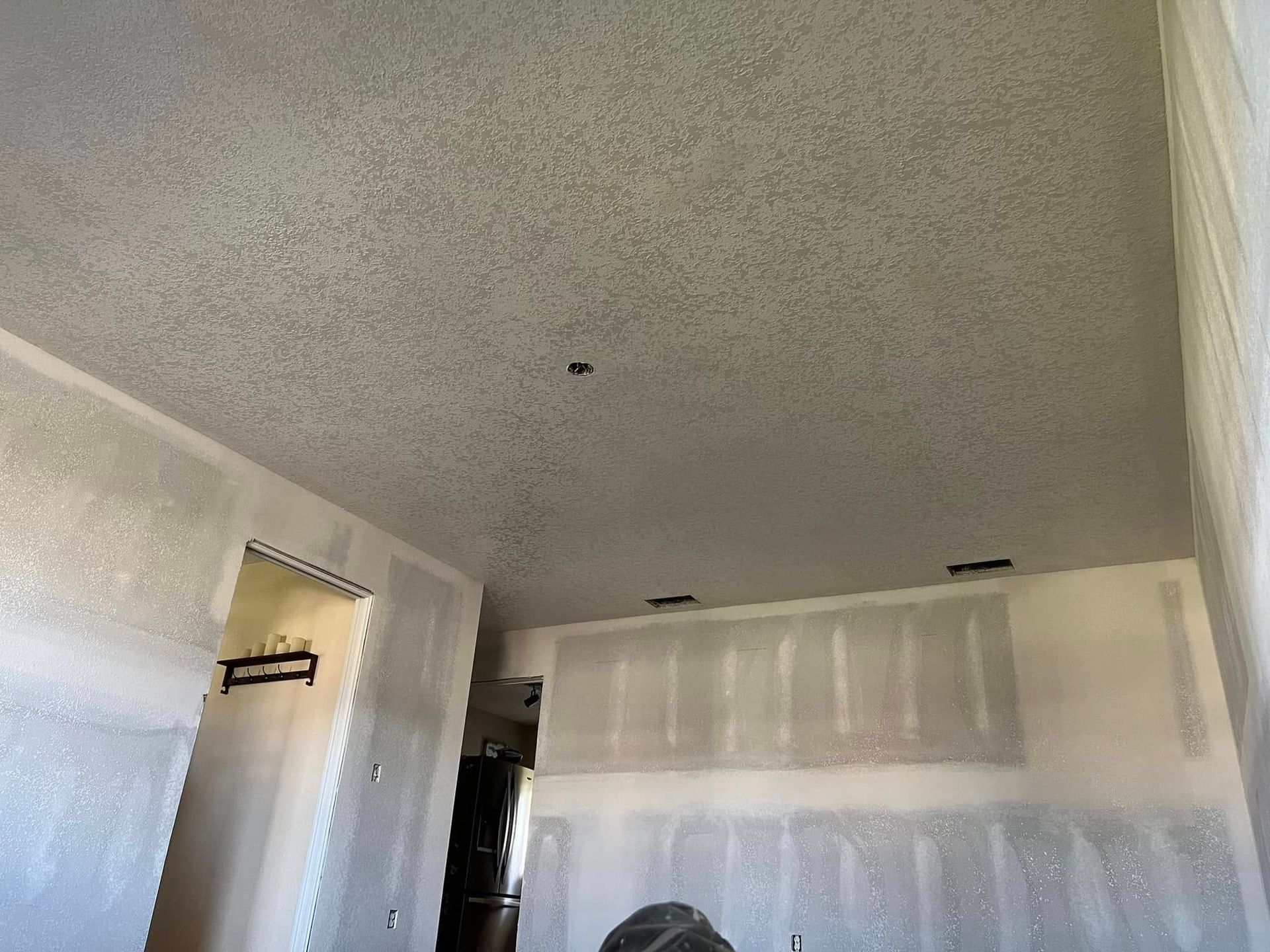 Interior room with unfinished drywall and textured ceiling.
