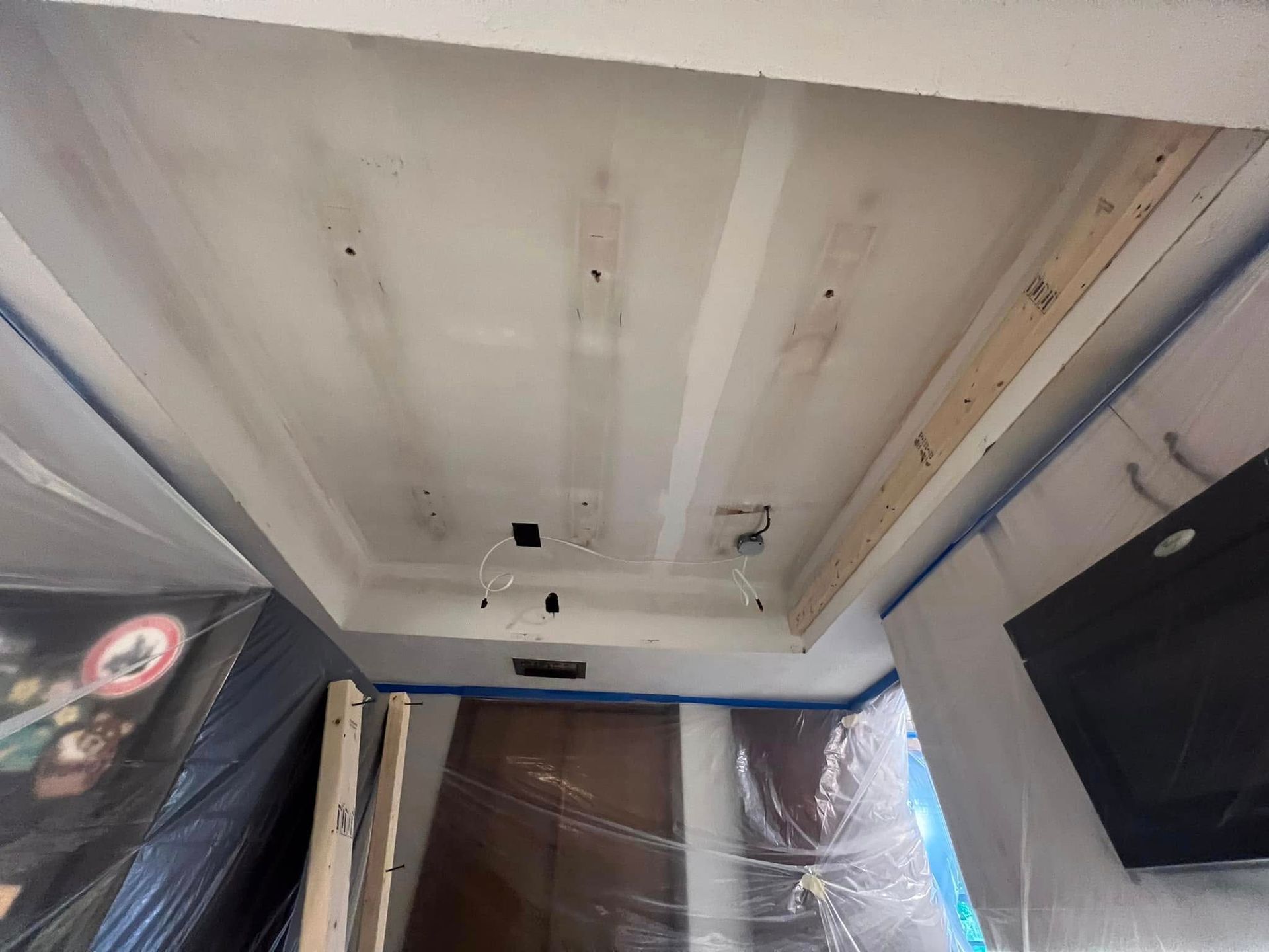 Ceiling under construction, with exposed beams, electrical wiring, and fresh drywall.