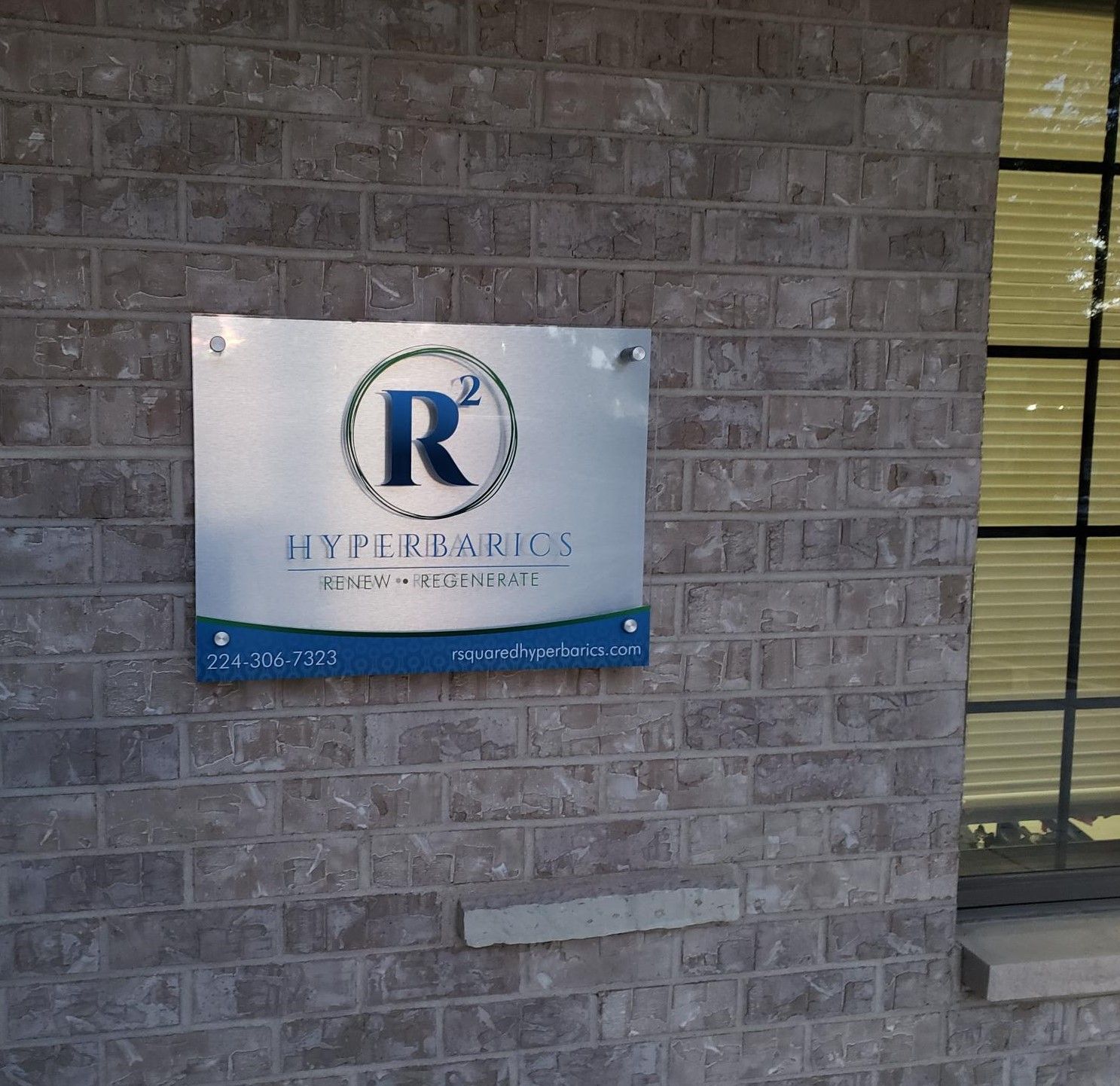 A sign on a brick wall that says r on it