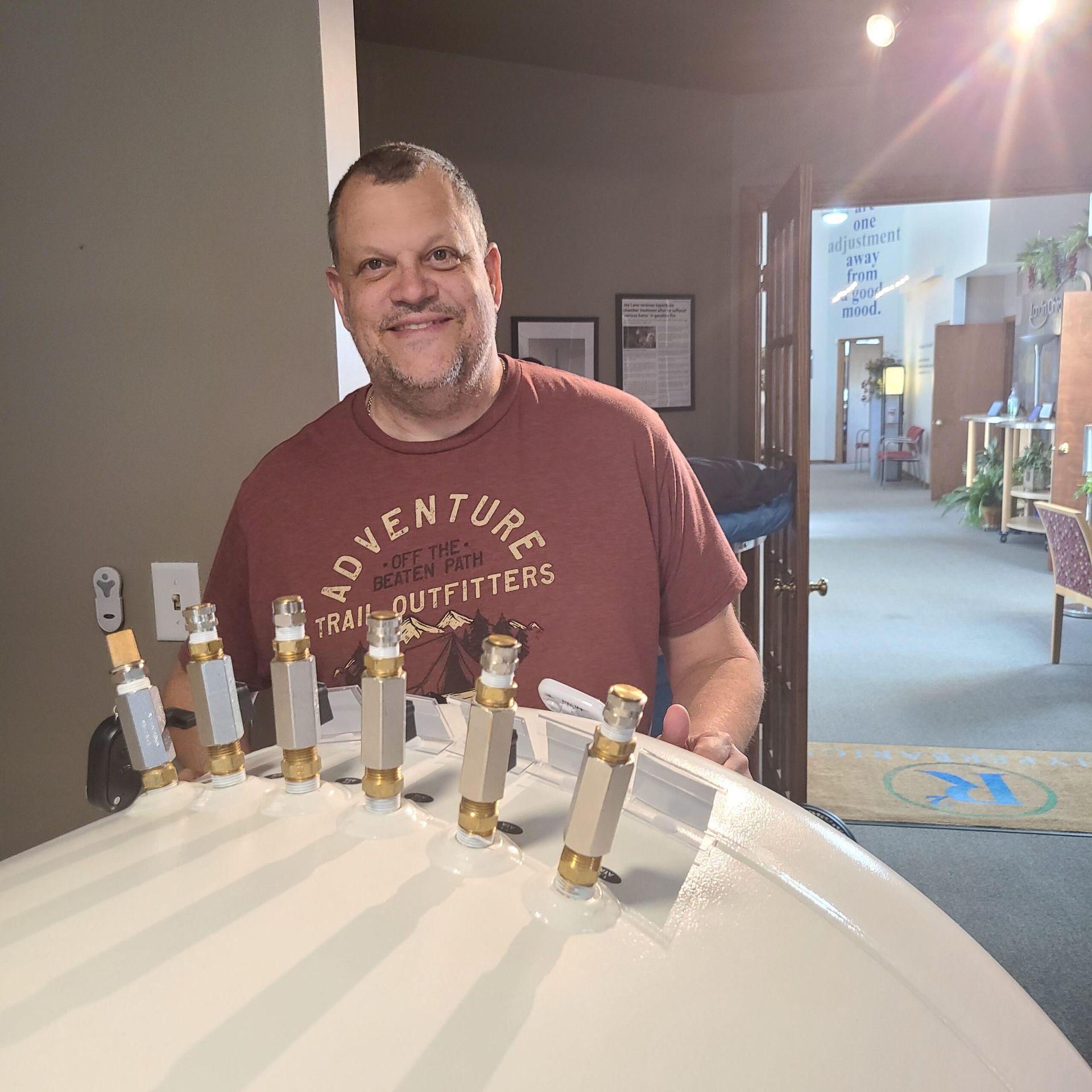 A man wearing a red shirt that says adventure on it