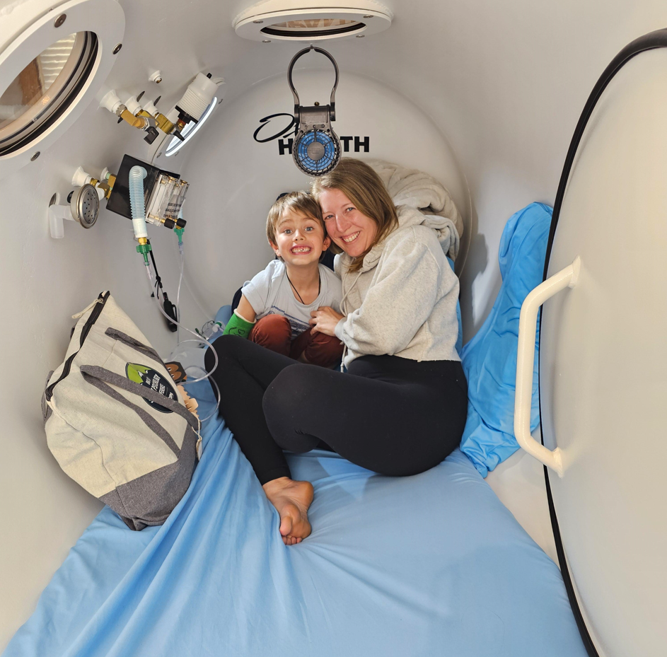 A woman and child are sitting in a room with the word roth on the wall
