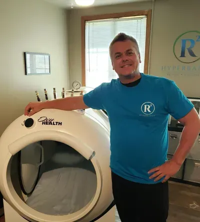 A man in a blue shirt is standing next to a machine that says pure health