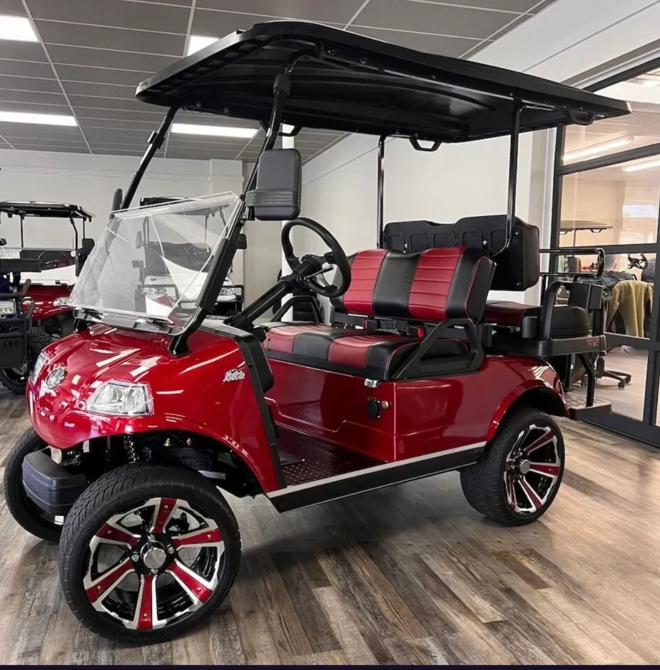 A red golf cart is parked in a showroom