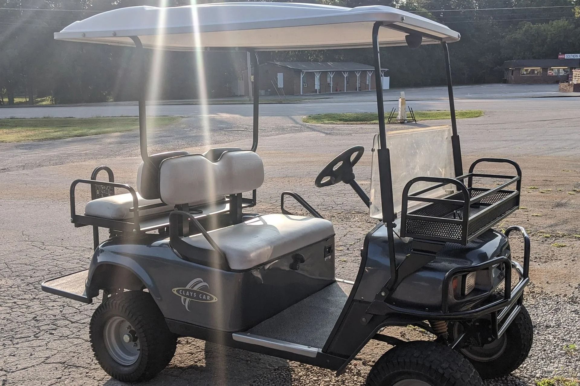 A golf cart is parked in a gravel lot