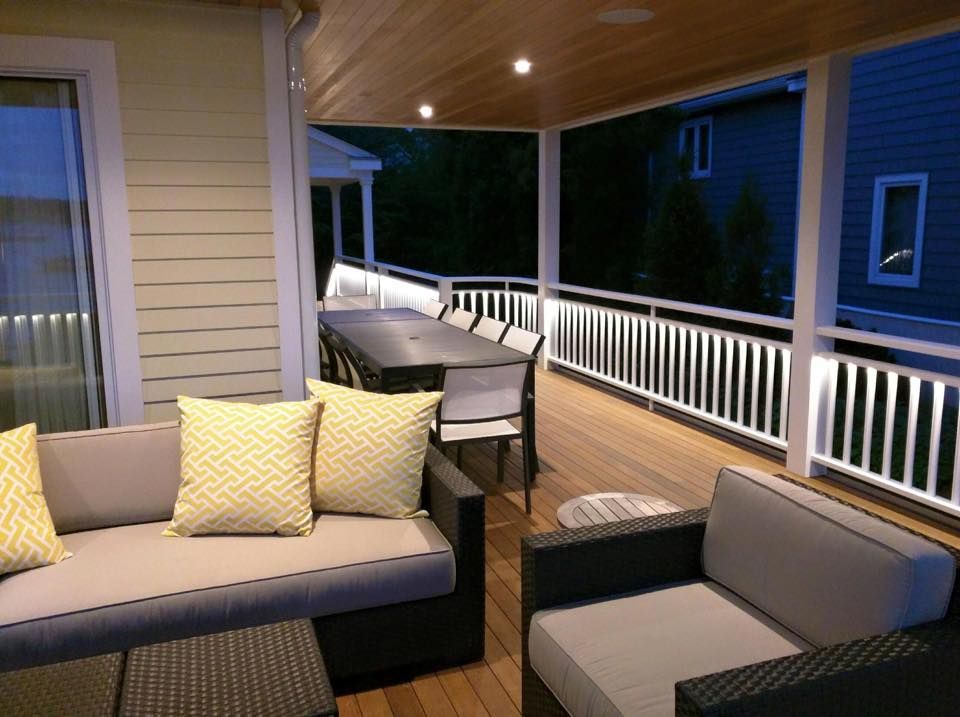 A porch with a couch and chairs and a table