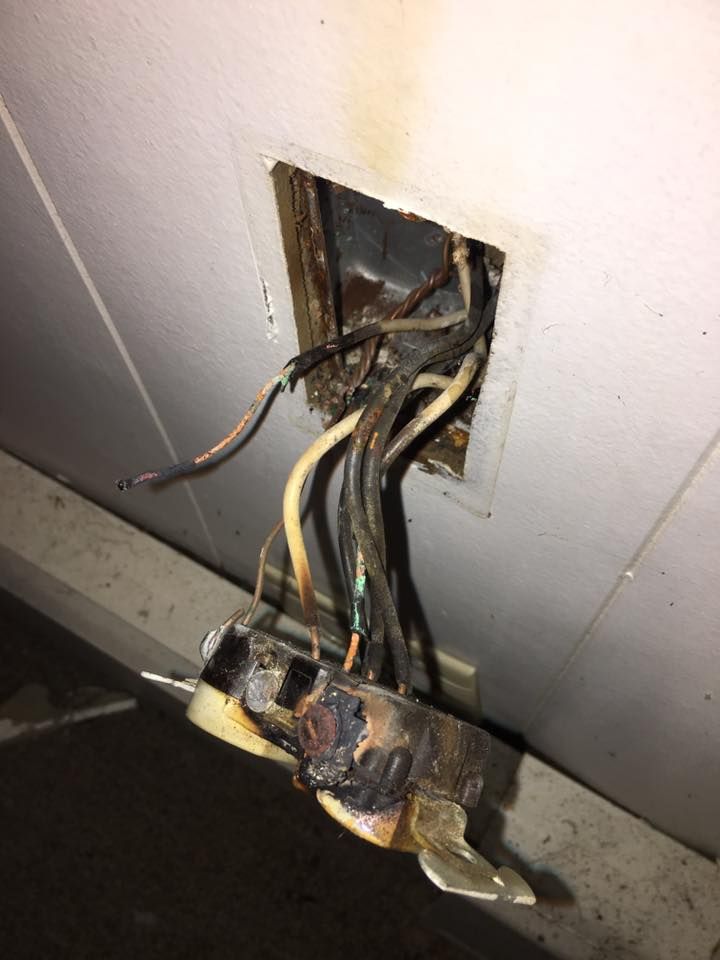 A close up of an electrical outlet with wires coming out of it.