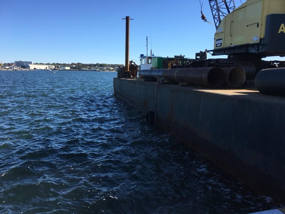 A large yellow crane is sitting on a dock near the water