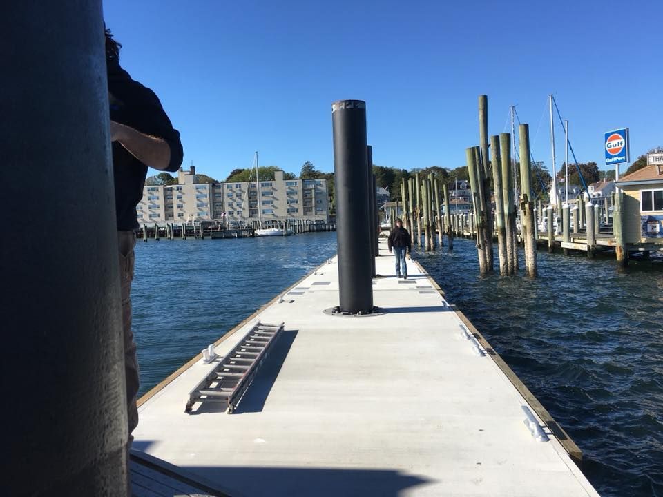 A person standing on a dock with a pepsi sign in the background